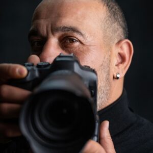 Portrait of Male Photographer Holding Camera in Studio, Close Up